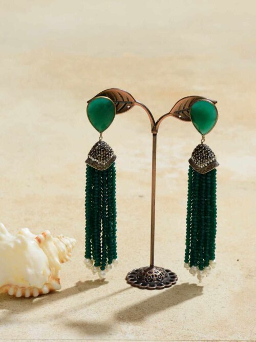 Exquisite earrings showcasing polished jade droplets, reminiscent of gentle raindrops, suspended gracefully, offering a serene and earthy elegance