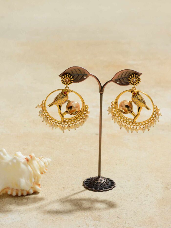 Golden earrings depicting detailed parrots perched elegantly